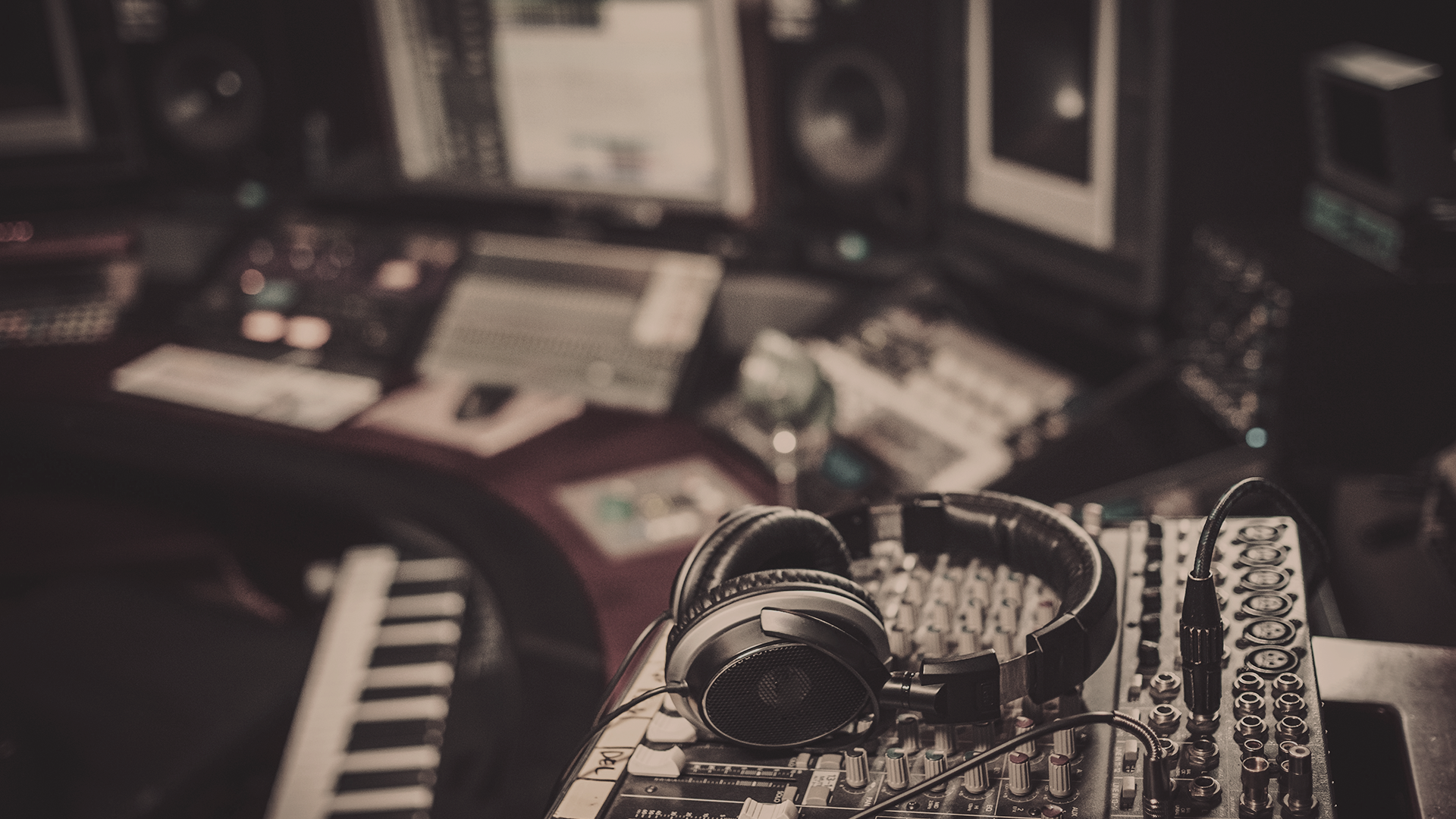 Photo of a silhouette of 2 dancers posing in front of a red curtain.