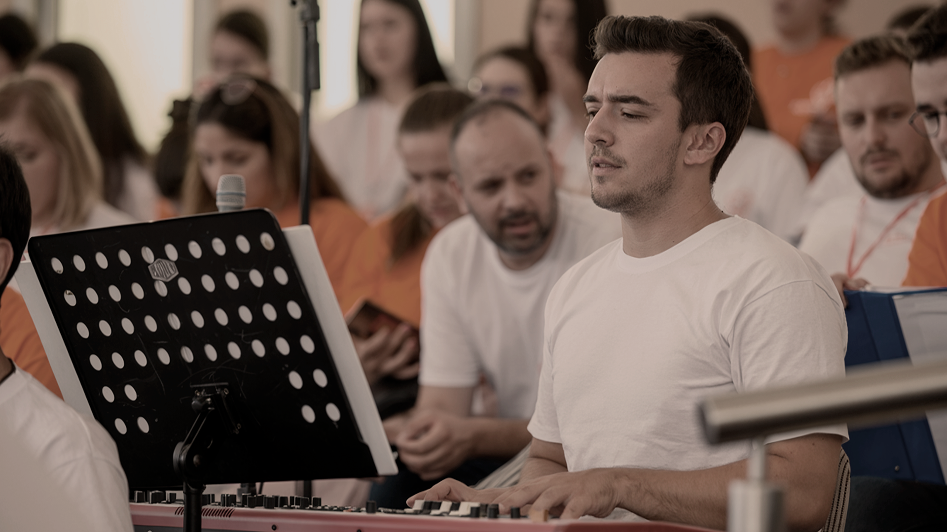 Photo of a silhouette of 2 dancers posing in front of a red curtain.